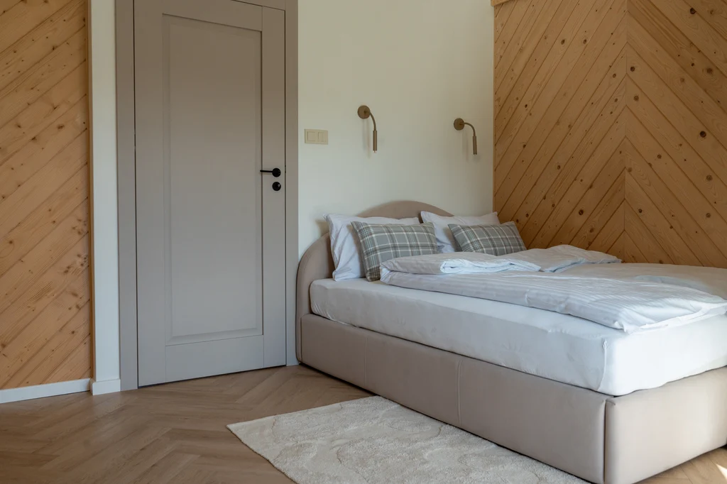 Bedroom beneath a wooden sloping ceiling