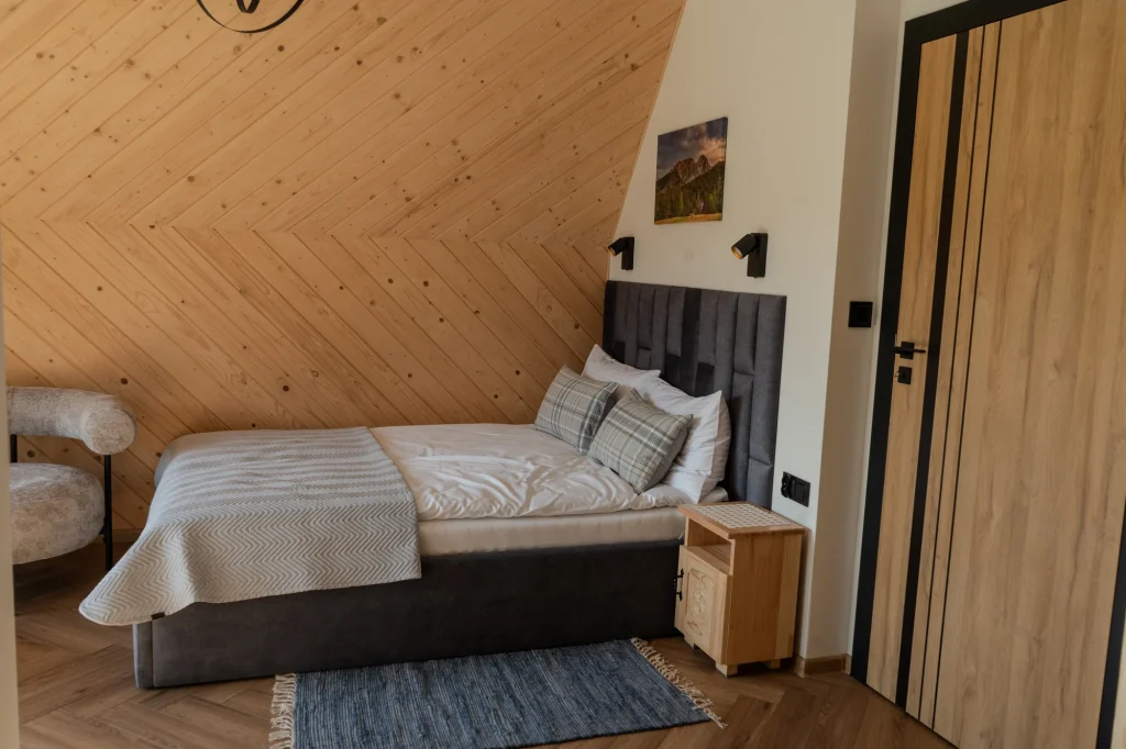 Bedroom beneath a wooden sloping ceiling